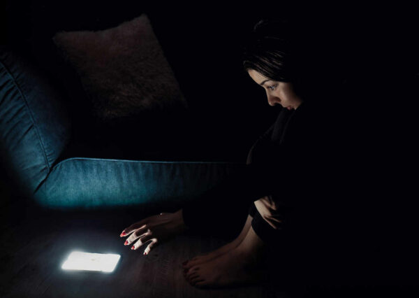 Kobieta sięgająca po telefon w nocy